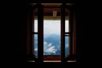 Blick durch offenes Fenster auf Berglandschaft — Stockfoto