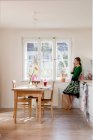 Woman in kitchen talking on a phone — Stock Photo