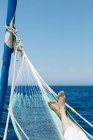 Woman's feet in hammock on sailing boat — Stock Photo