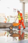 Worker carting concrete on site — Stock Photo