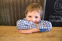 Lächelnder Junge stützt sich auf Theke — Stockfoto
