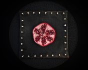 Sliced pomegranate on decorative board — Stock Photo