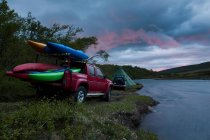 Canoas en camión cama por río - foto de stock