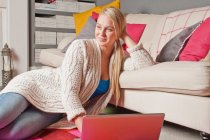 Donna che utilizza laptop e sognare ad occhi aperti a casa — Foto stock