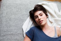 Над головой вид женщины лежащей на одеяле — стоковое фото