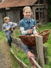 Дівчинка і хлопчик на паркані з яблуками — стокове фото