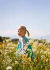 Menina andando no campo de flores — Fotografia de Stock