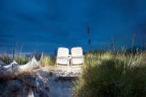 Chaises de plage éclairées sur une dune de sable — Photo de stock