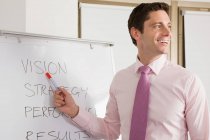 A lecturer pointing at whiteboard — Stock Photo