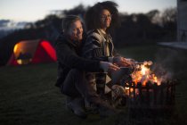 Couple toasting marshmallows at camp, Isle of Skye, Scotland — Stock Photo