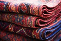 Rugs stacked in market stall — Stock Photo