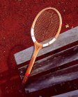 Tennis racket on bench — Stock Photo
