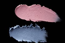 Fard à paupières bleu et rose étalé sur fond noir — Photo de stock