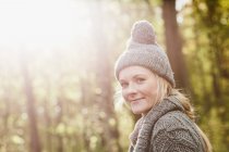 Lächelnde Frau geht im Wald spazieren — Stockfoto