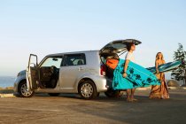 Casal tomando pranchas de surf da bota do carro — Fotografia de Stock