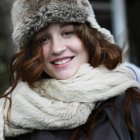 Femme souriante portant chapeau et écharpe — Photo de stock