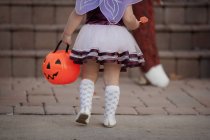 Cropped rear view of Toddler carrying Jack O Lantern bucket — Stock Photo