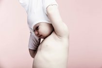 Portrait of baby girl taking off top — Stock Photo