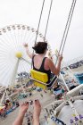 Woman waving from amusement park swings — Stock Photo