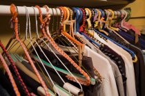 Одежда на красочных вешалках в шкафу — стоковое фото