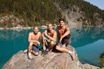 Três homens sentados na rocha, Lago Garibaldi, Parque Provincial Garibaldi, Colúmbia Britânica, Canadá — Fotografia de Stock