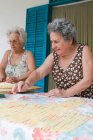 Mujeres mayores haciendo pasta juntas, enfoque selectivo - foto de stock