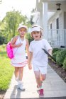 Portrait of boy and girl tennis players on garden path — Stock Photo