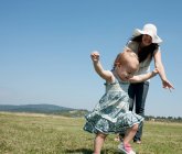 Mutter und Tochter gehen auf Feld — Stockfoto