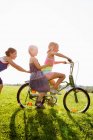 Ragazze che giocano con la bicicletta in erba — Foto stock