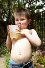 Ragazzo che beve succo in giardino — Foto stock