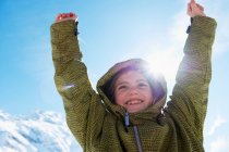 Girl cheering on snowy mountain top — Stock Photo