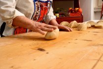 Woman rolling dough on board — Stock Photo