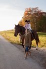 Frau geht mit zwei Mädchen auf einem Pferd — Stockfoto