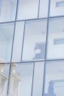 Donna d'affari in cerca di lasciare stanza di vetro frontale hotel mentre si parla su smartphone — Foto stock