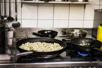 Pfannen mit Lebensmitteln kochen auf Herd in Küche — Stockfoto