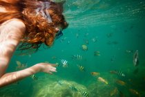 Chica haciendo snorkel en aguas tropicales - foto de stock