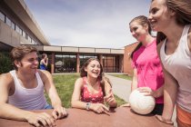 Ученики старших классов, имеющие волейбольную команду, разговаривают вне школы — стоковое фото