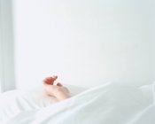 Hand of a female resting on a pillow — Stock Photo