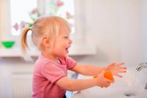 Маленькая девочка, моющая руки — стоковое фото