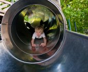Rapaz a deslizar por um túnel — Fotografia de Stock