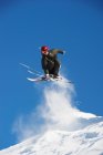 Лыжник прыгает со снежного склона — стоковое фото