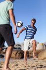 Чоловіки грають у футбол на пляжі, вибірковий фокус — стокове фото