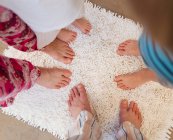 Сімейні ноги на білому килимку для ванни — стокове фото