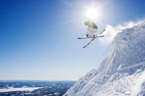 Чоловік стрибає на лижах зі схилу — стокове фото