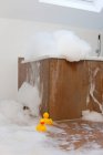 Bañera rebosante de espuma y patos de goma - foto de stock