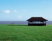 Shelter on green field with sea view — Stock Photo