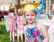 Portrait of young girl at kindergarten graduation, wearing paper mortar board — Stock Photo