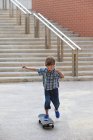 Мальчик играет со скейтбордом на открытом воздухе — стоковое фото