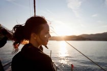 Mulher em um barco assistindo o pôr do sol — Fotografia de Stock