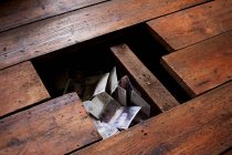 Fechar de Dinheiro sob tábuas de chão — Fotografia de Stock